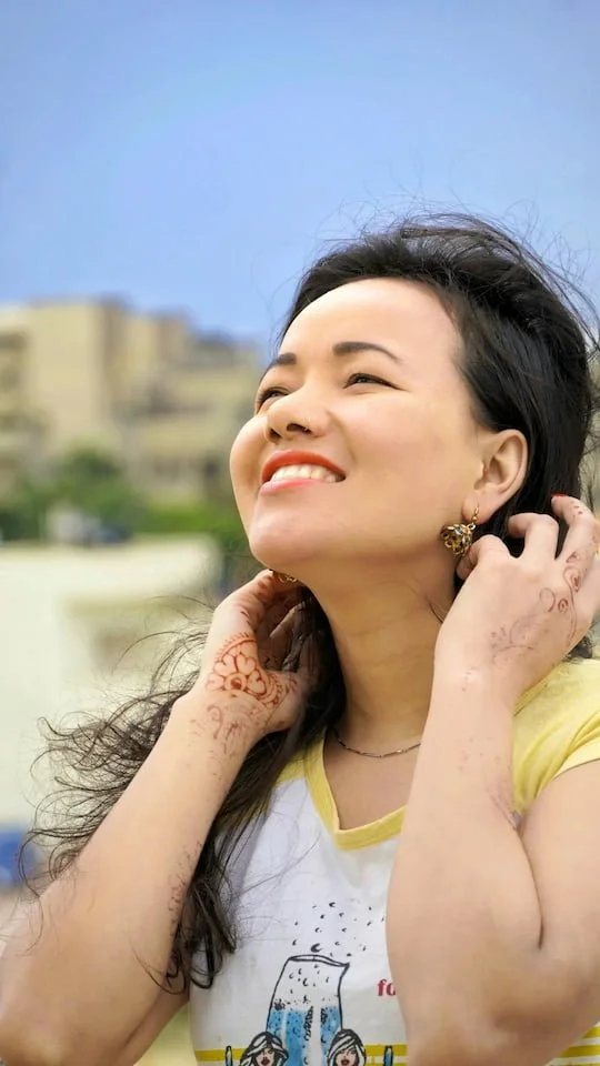 Smiling woman looking upward while standing outdoors