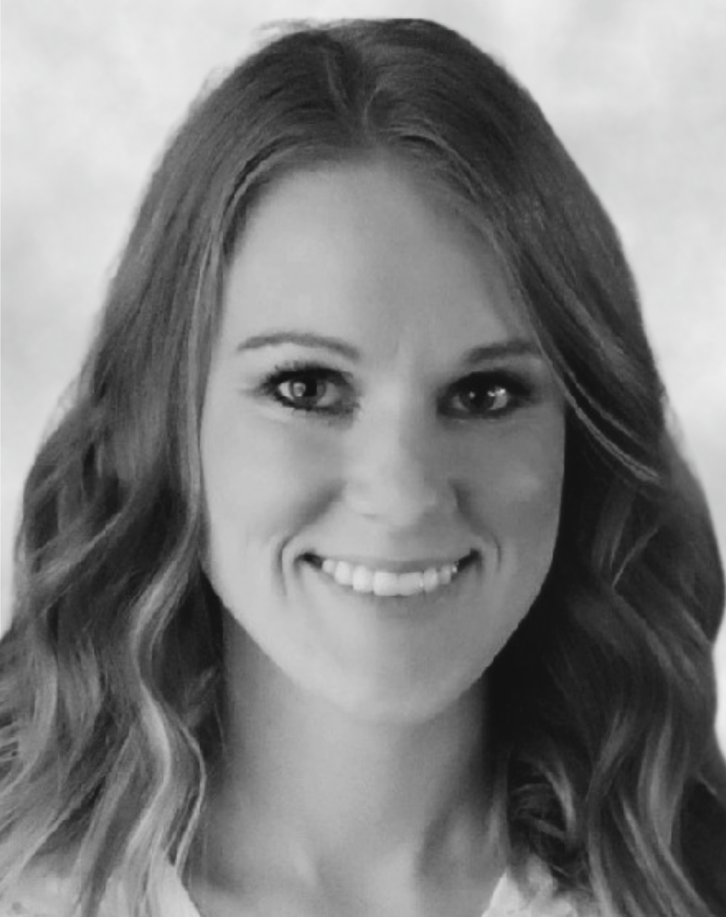 Black and white portrait of a smiling woman with wavy hair.