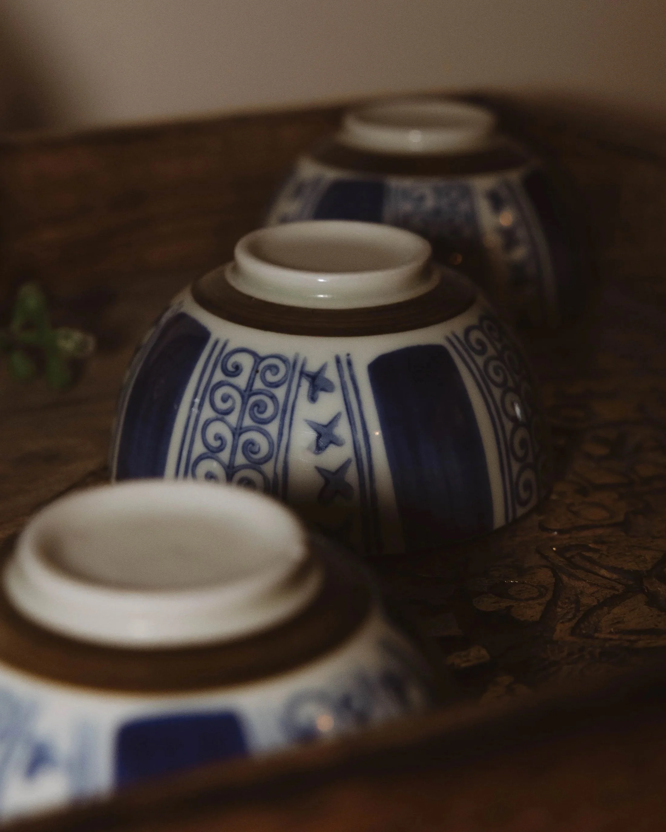 Trois bols en céramique avec décoration bleue et blanche, placés sur une surface en bois.