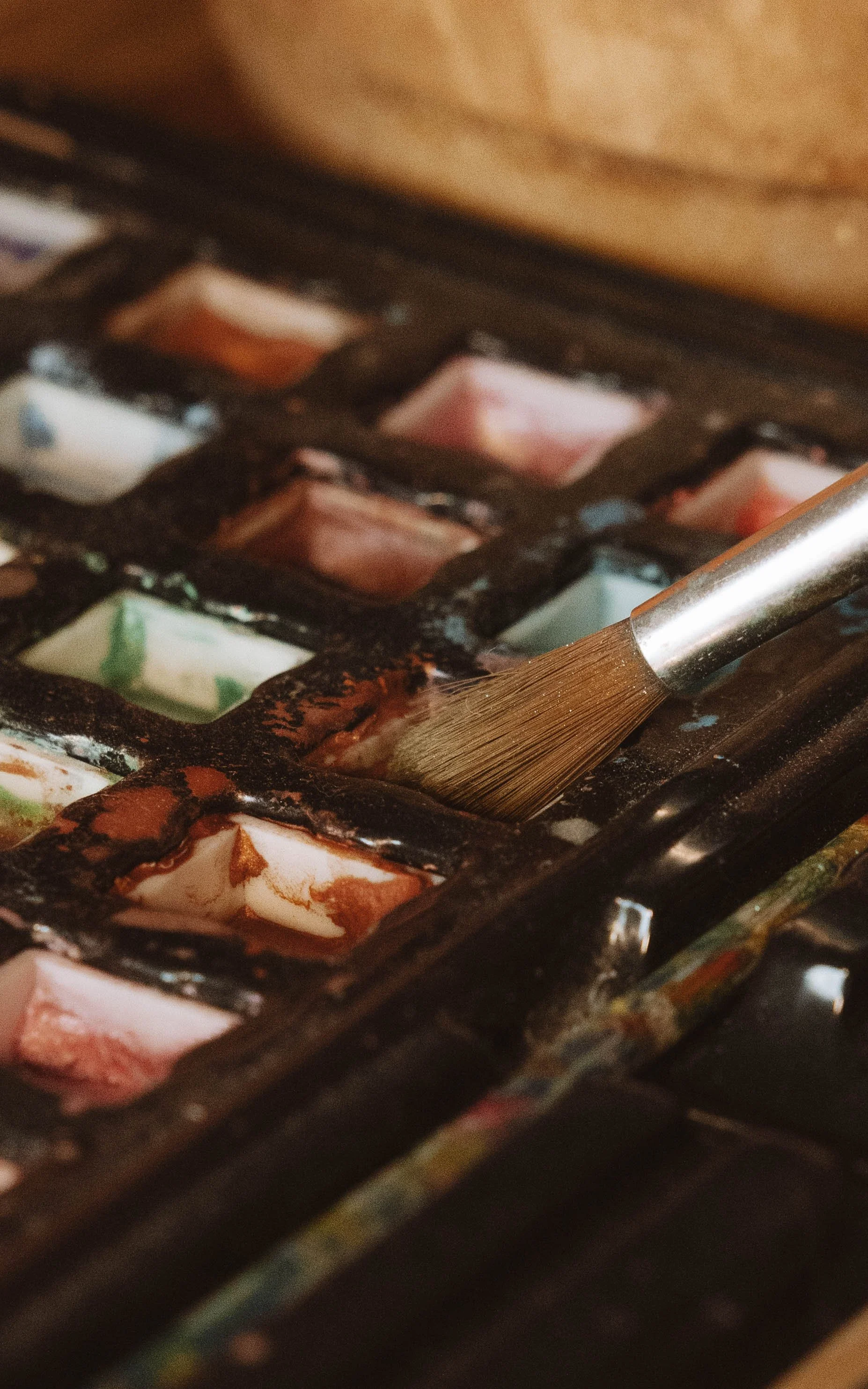 Coffret de peinture à l'huile avec un pinceau appliquant de la peinture sur une surface.