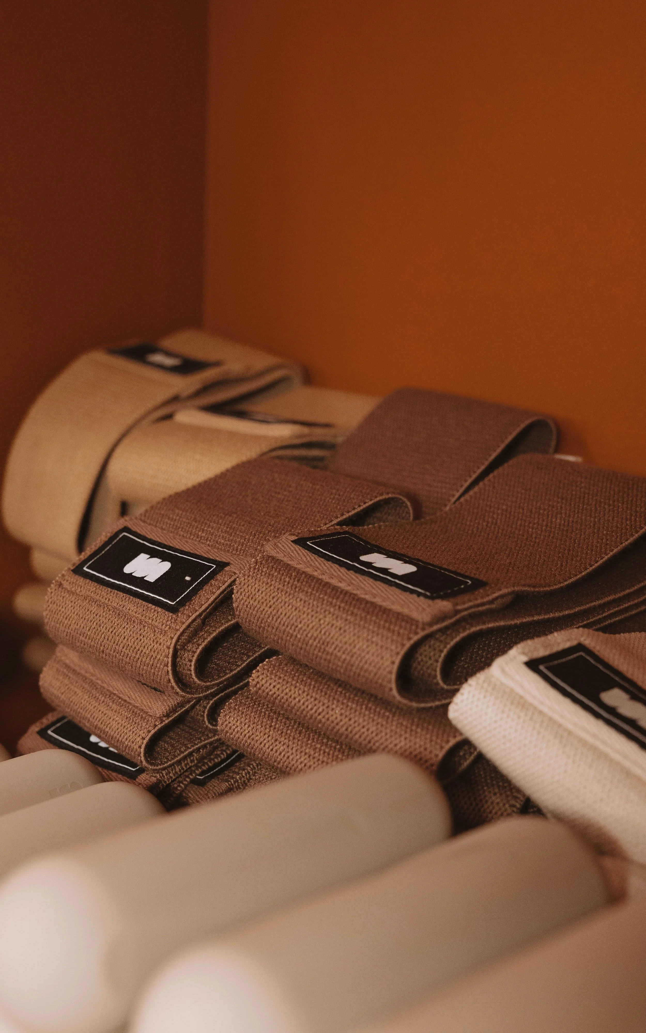 Une collection de bandes en tissu de différentes couleurs, comme beige, marron foncé et clair, avec des étiquettes noires et blanches.