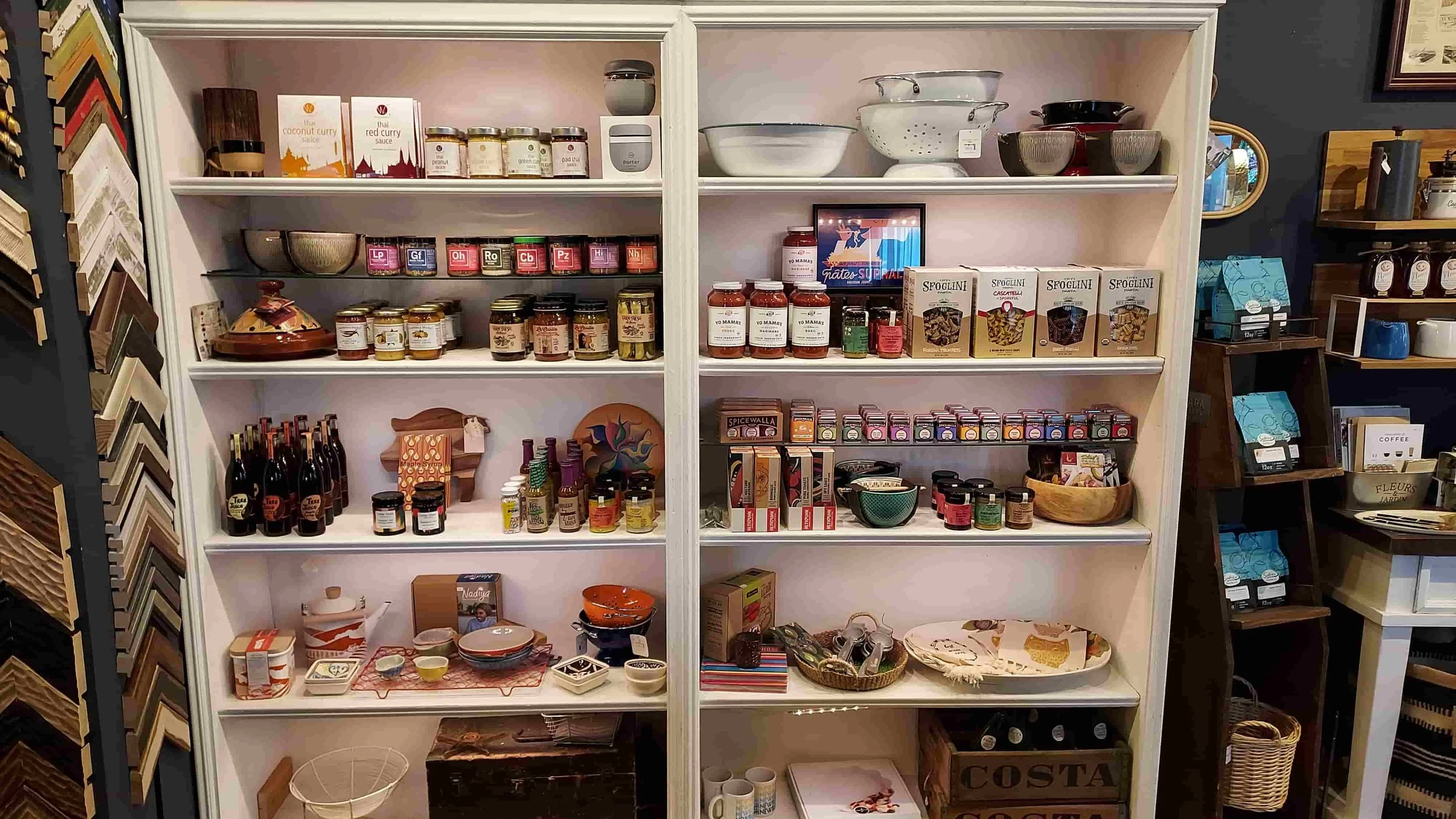 Wall display of gourmet pantry staples and kitchen items for sale at a gift shop in Newburgh, NY.