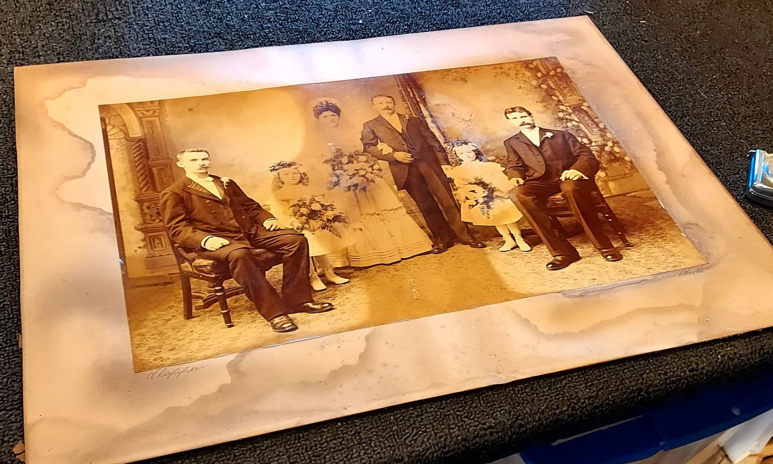 Close-up of a severely faded and water-stained sepia-toned antique wedding portrait.