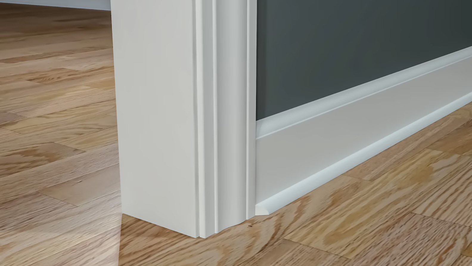 Close-up of a white door frame and baseboard on a hardwood floor.
