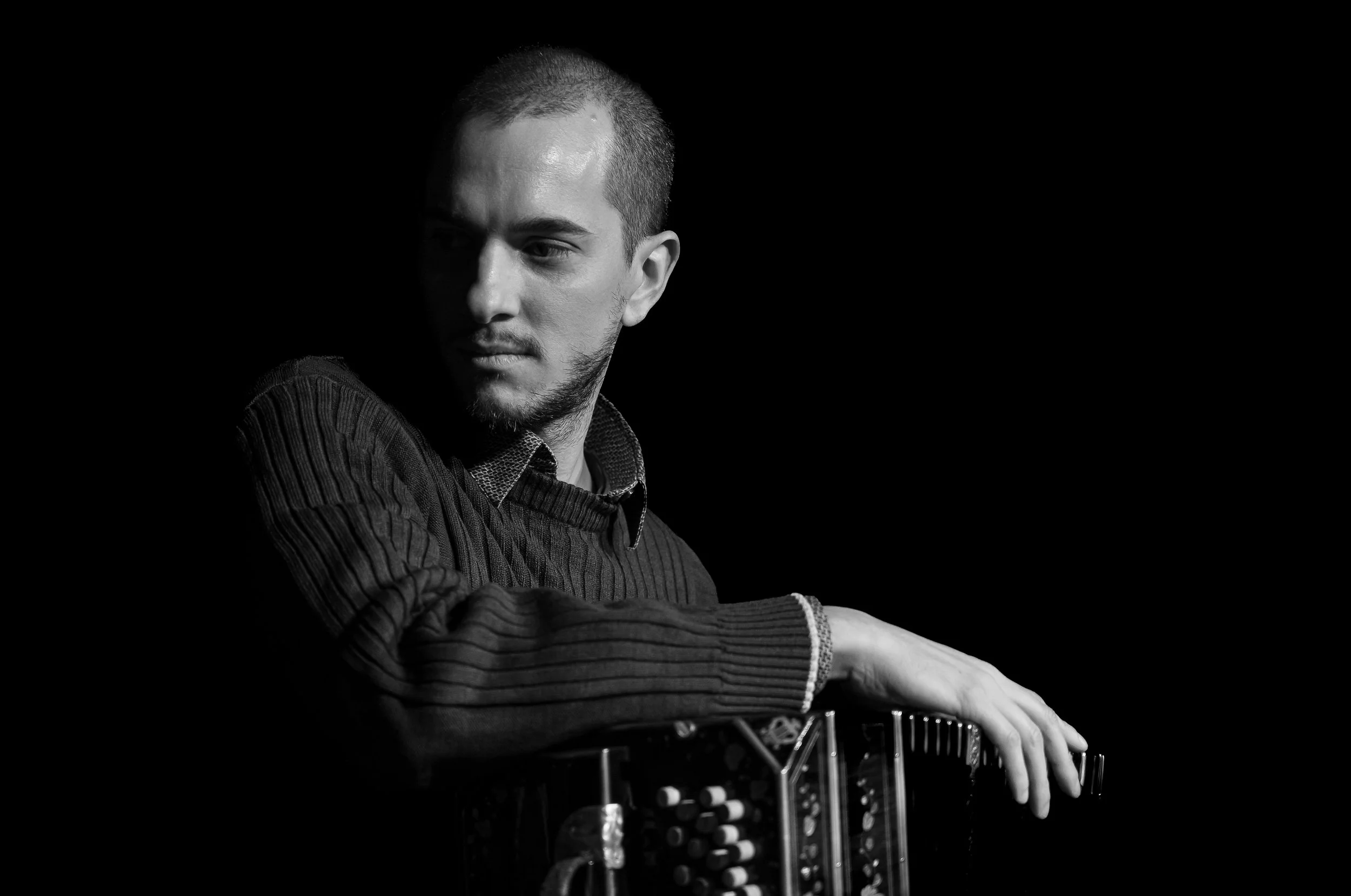 Black and white photo of Guillermo Willis playing Tango music with a bandoneon.