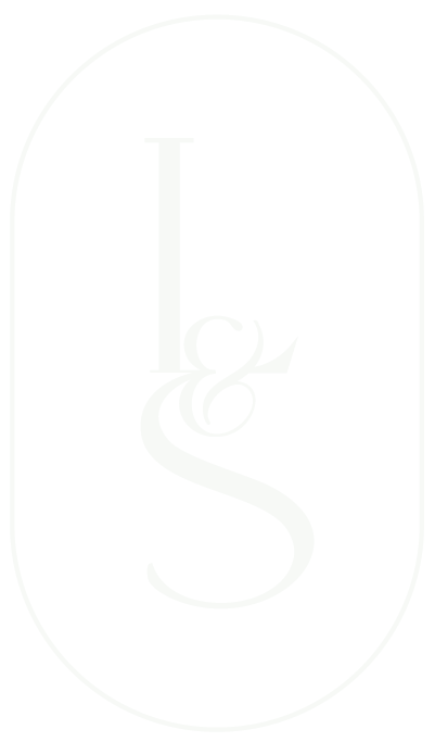 Black background with a white stylized monogram of the letter 'L' and an elegant ampersand intertwined in the center, enclosed in an oval outline.
