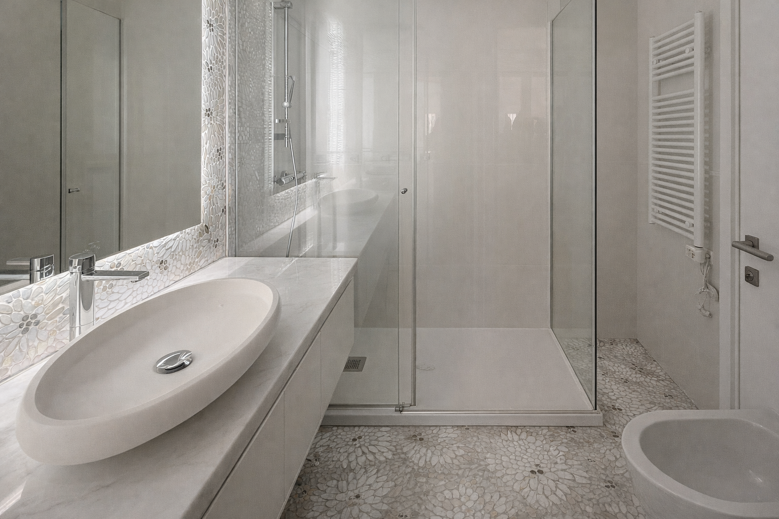 Baño con lavabo de ovalado, espejo grande, ducha con puertas de cristal, toallero eléctrico blanco y bidé.