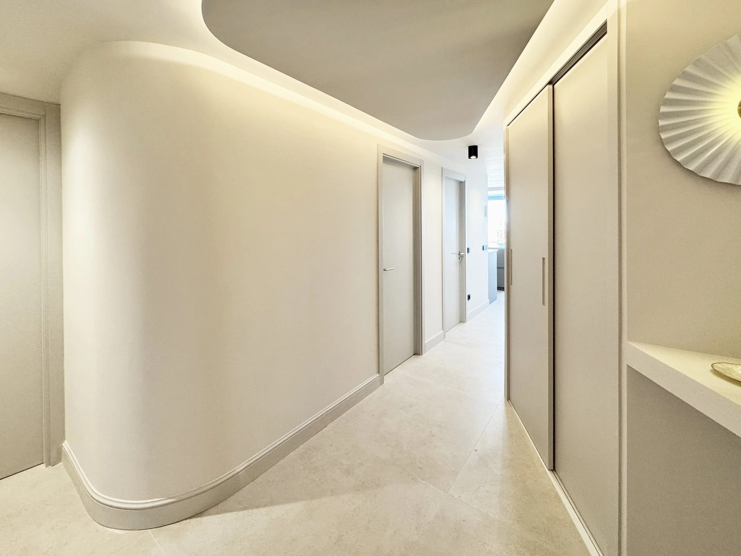 Pasillo de un apartamento moderno con paredes blancas y puertas cerradas