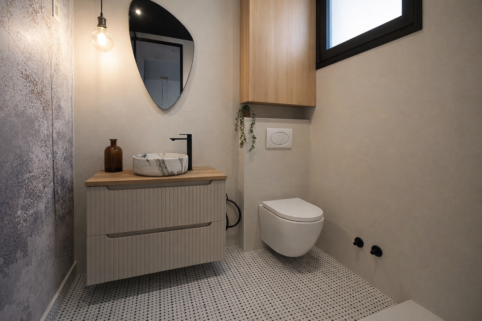 Baño moderno con lavabo de piedra, espejo de forma irregular, inodoro suspendido, pared beige, mueble de madera y detalles decorativos