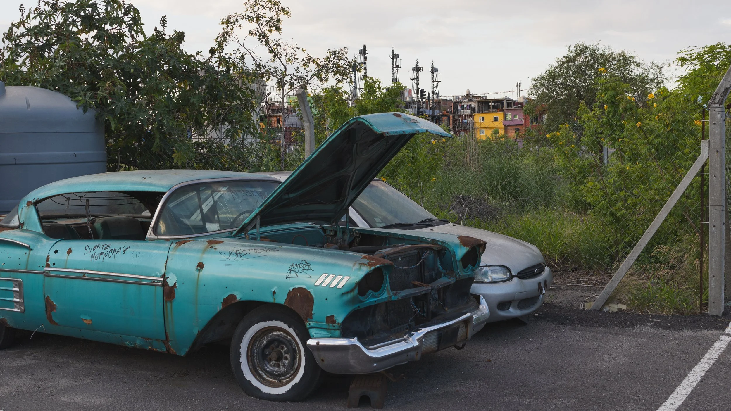 Colorful old car against slum