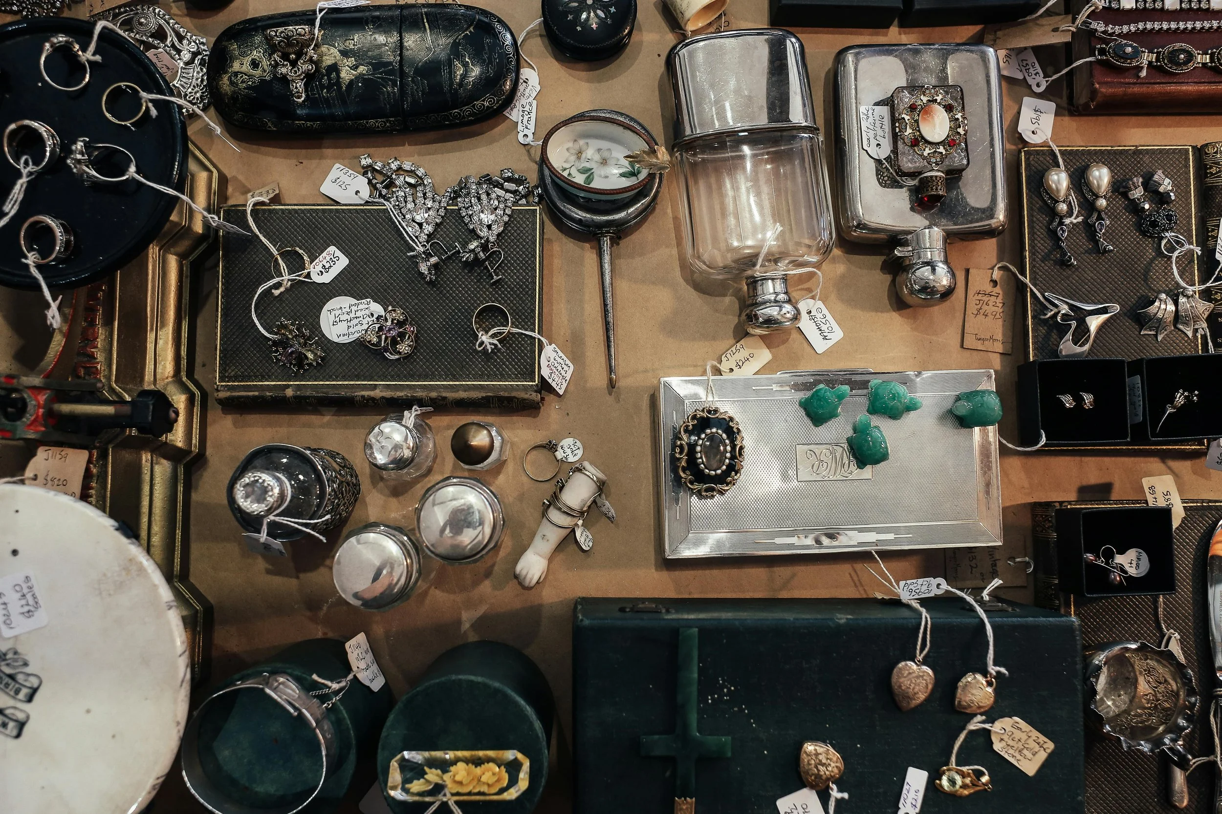 assorted estate items including jewelry and small valuables displayed and tagged for sale during estate clear out process