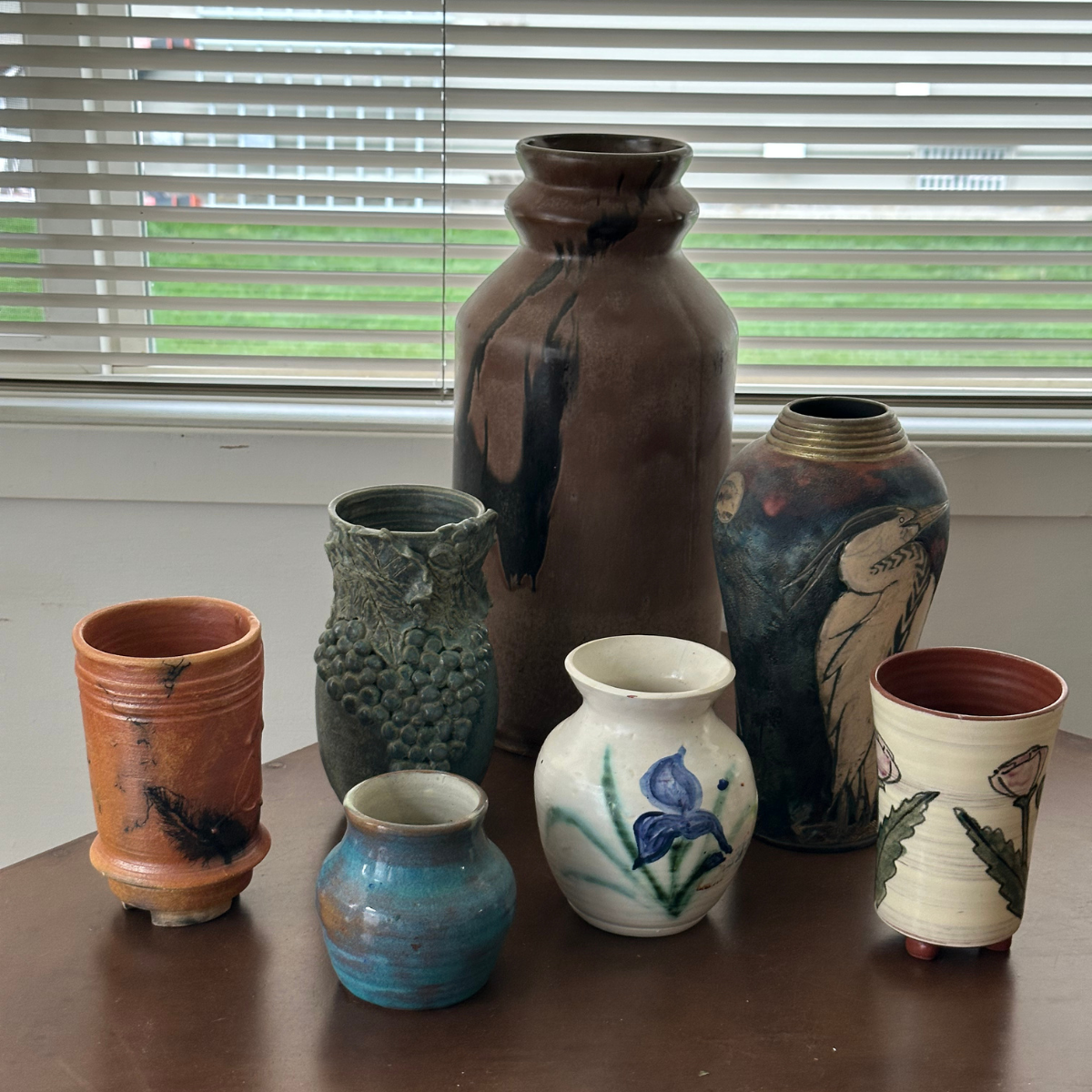 A collection of pottery and decorative vessels displayed on a table, representing estate items being identified and evaluated for potential sale.