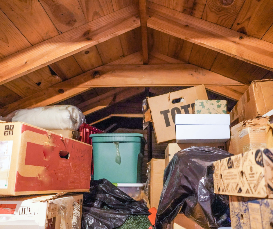 Storage attic filled with cardboard boxes, plastic containers, and miscellaneous items.