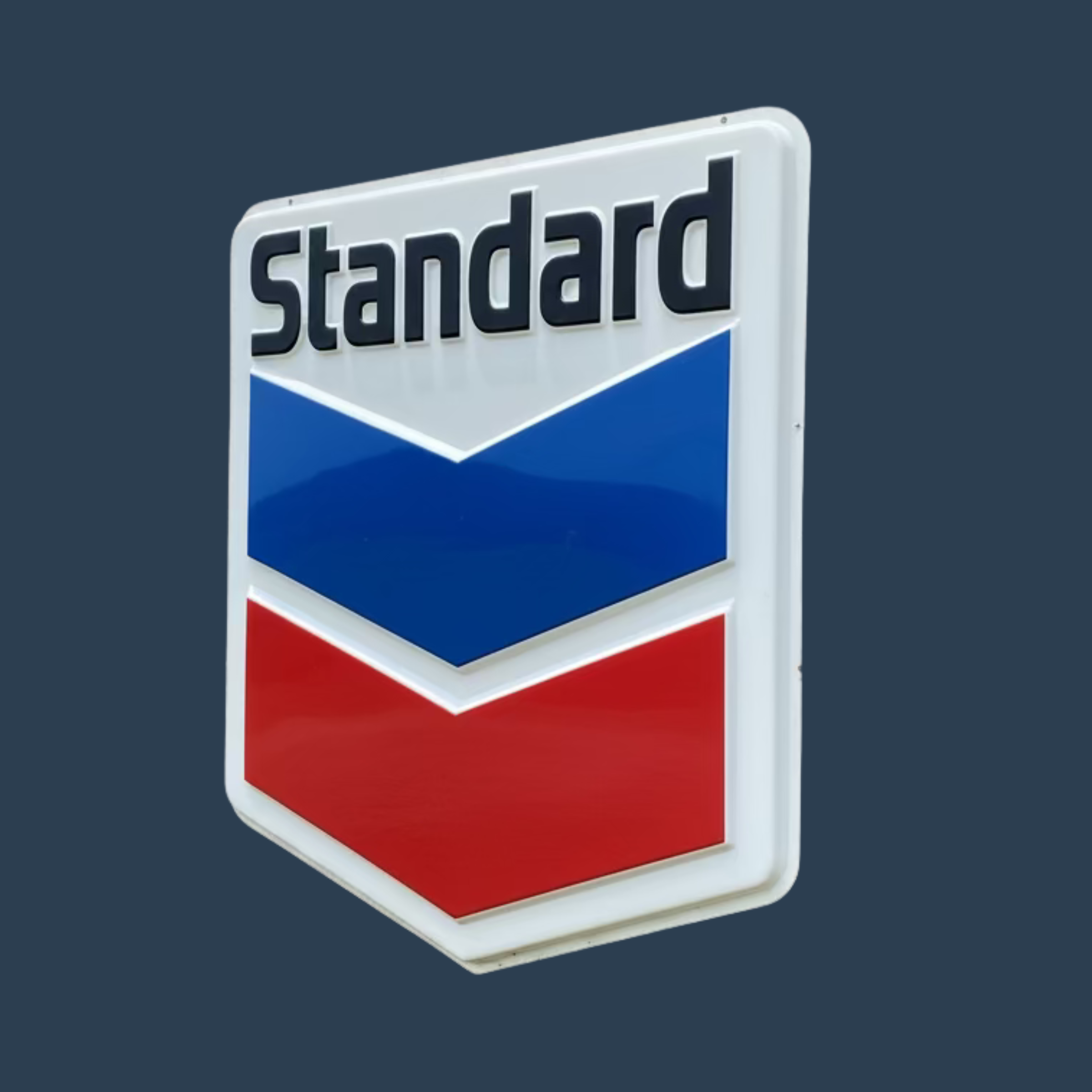 Vintage Chevron gas station sign for sale as part of an estate sale with the word 'Standard' at the top in black letters against a dark background.