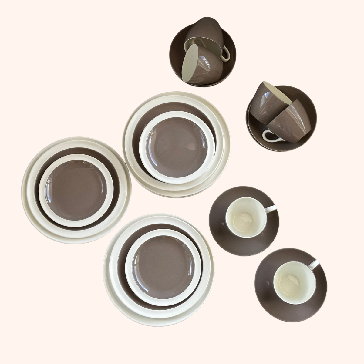 Set of brown and white ceramic cups and bowls arranged on a light background