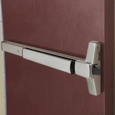 Automatic door closer mounted on a door with a pinkish-red surface.