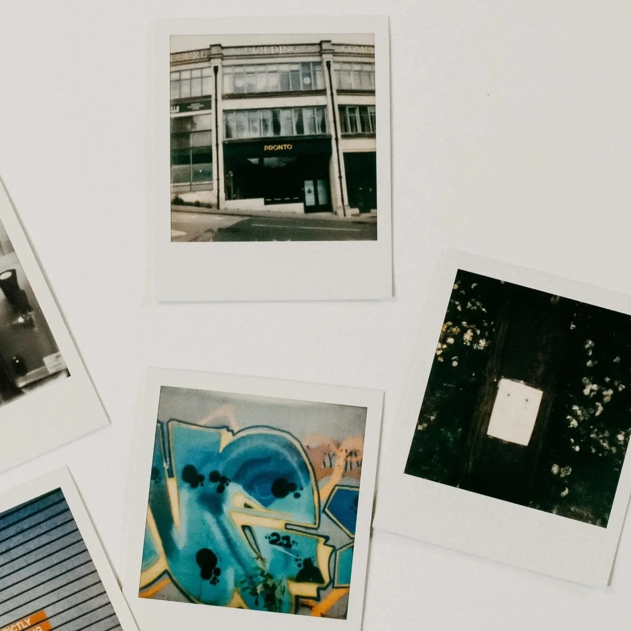 Photographs of urban and artistic scenes, including a building facade with a store sign, graffiti art with a blue theme, and a wall with plants and a smaller white square.