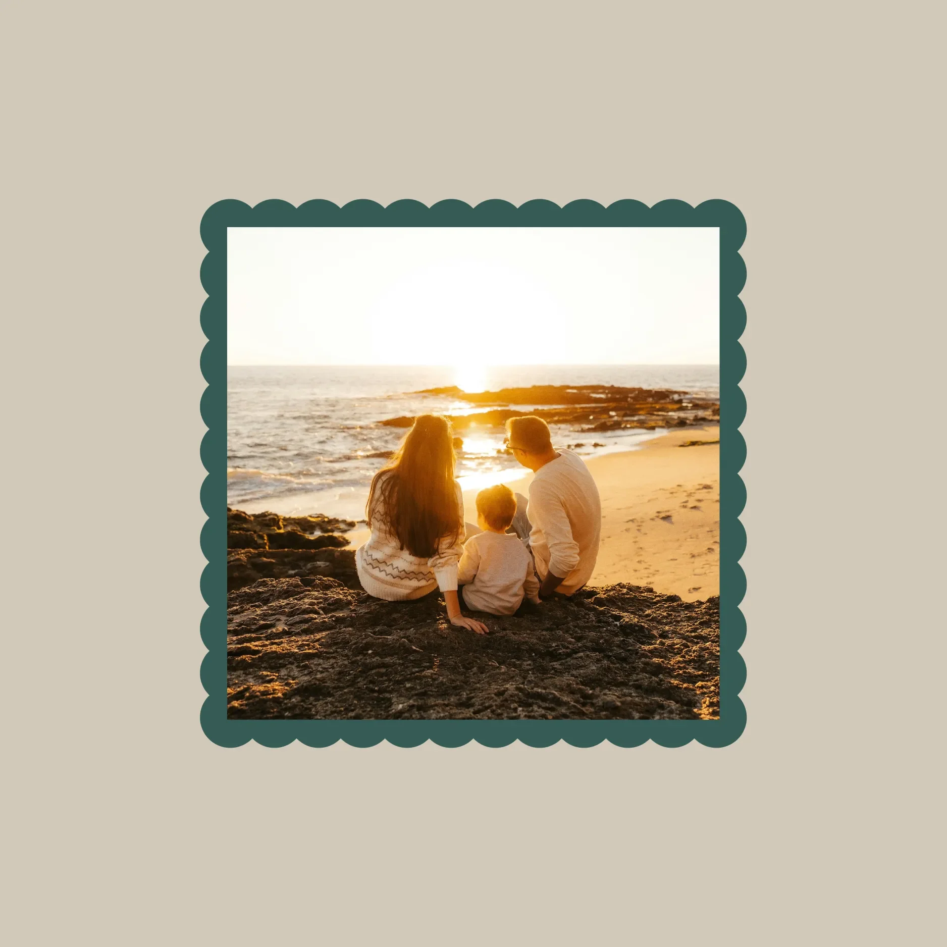 A family sitting on rocks at the beach watching the sunset