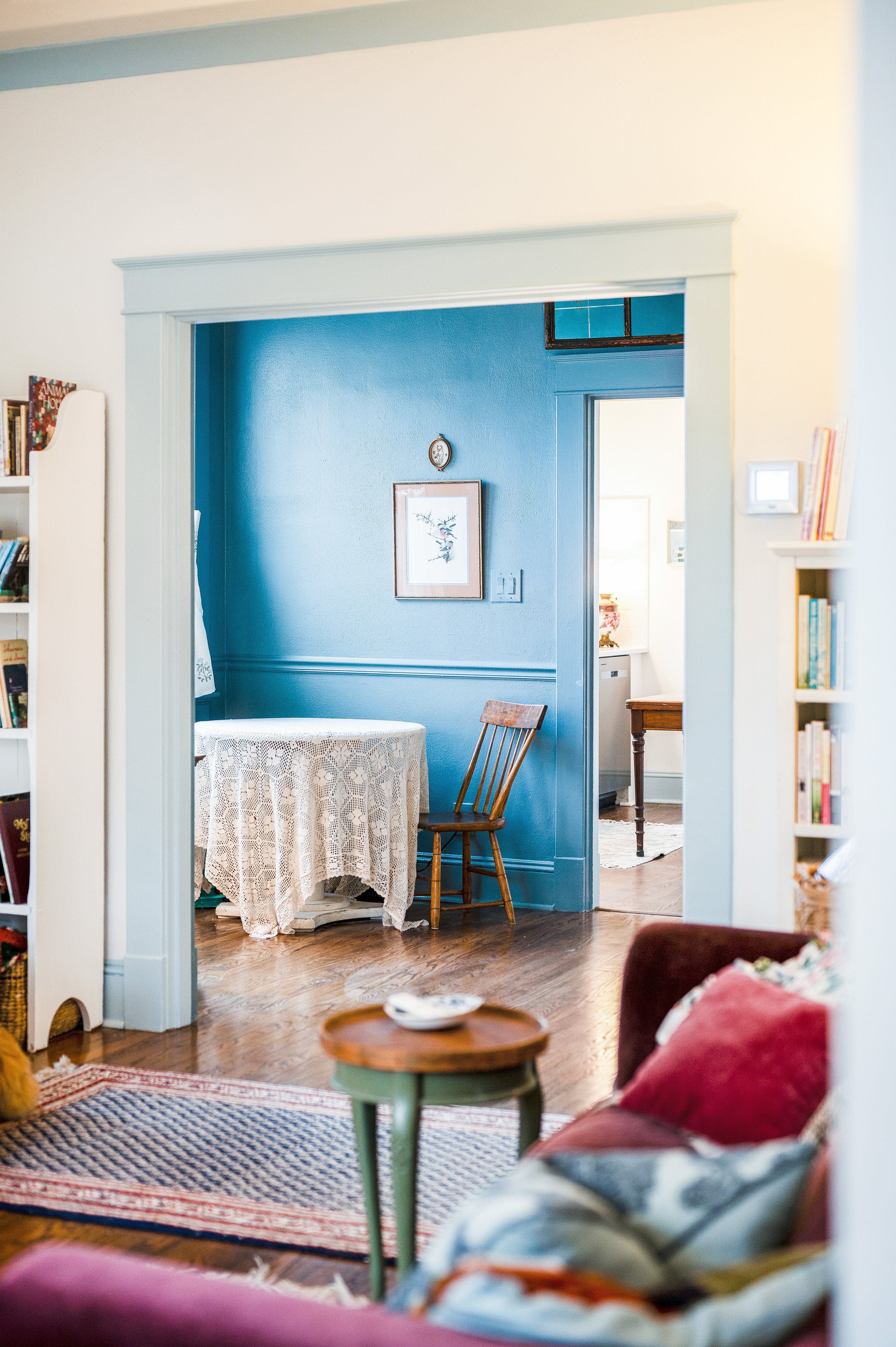 Color drenching and painted trim were common in the late Victorian and Art Deco periods. Blue trim  wasn't even half formed as an idea before my mind saw the encased opening framing a tiny, color-drenched dining room, grounding the house's center. 