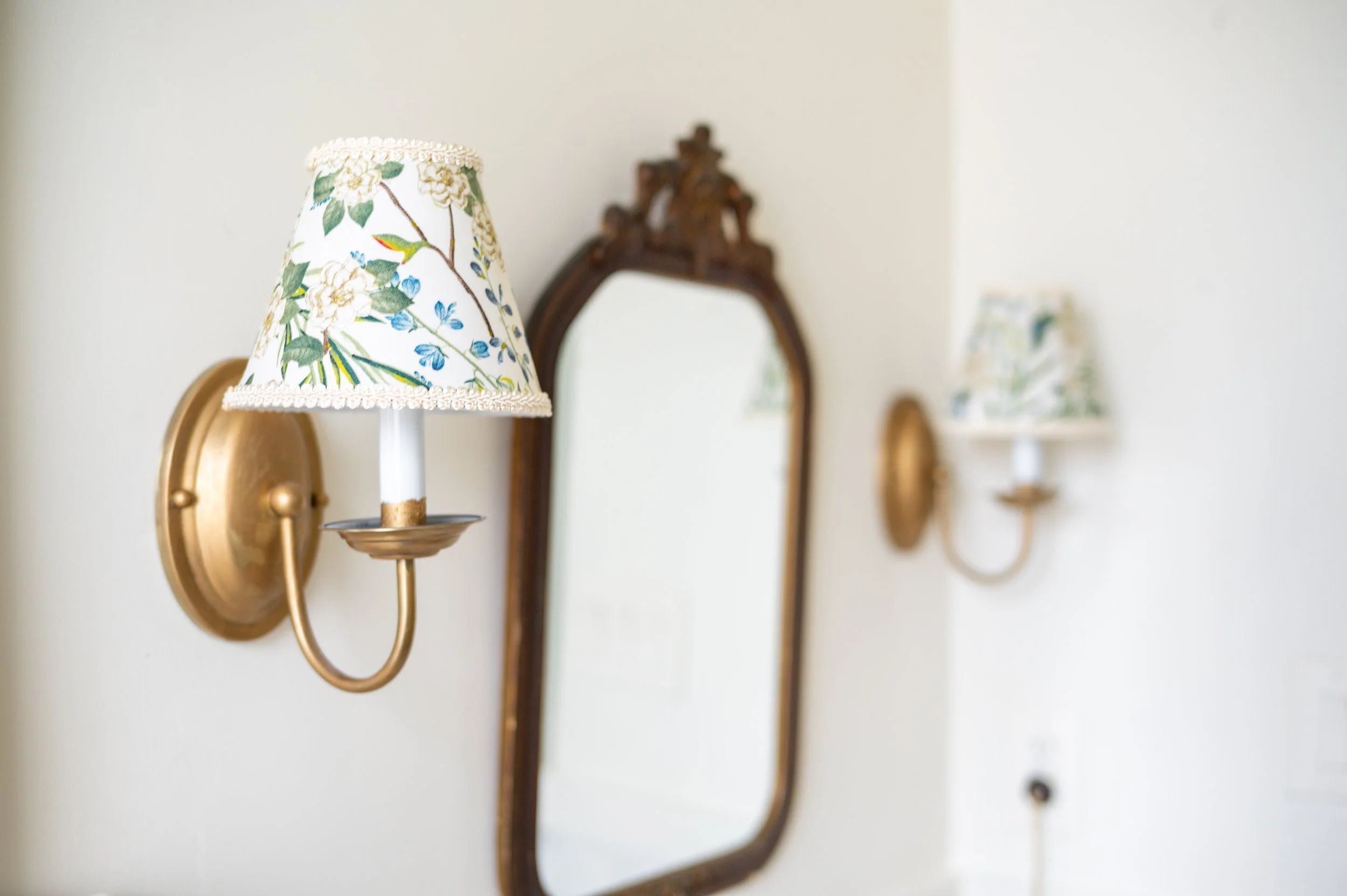 The over-sink light fixture wasn't my style, so in came a pair of affordable Home Depot sconces, Rub 'n Buffed for a warmer, deeper gold finish than their original factory-brushed brass. They look great with or without shades, but I love the dimensio