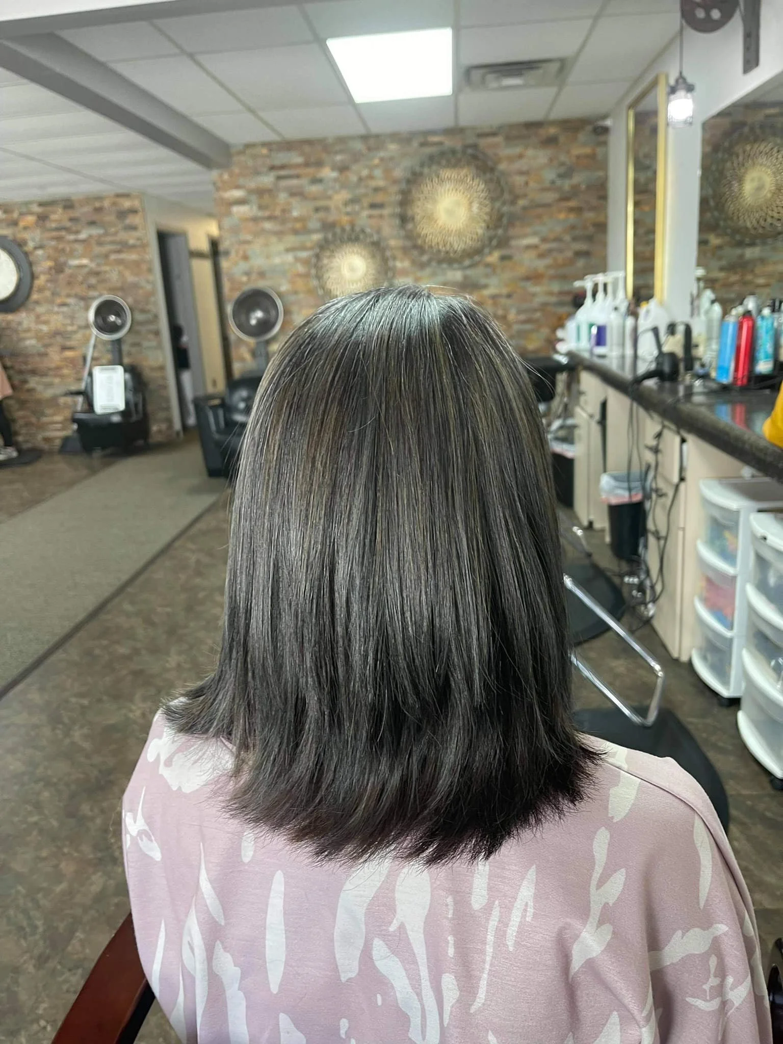 Sleek, modern haircut and freshly styled hair at New Dimensions Full Service Salon & Women’s Boutique in Fort Madison, Iowa, highlighting a polished, contemporary look.