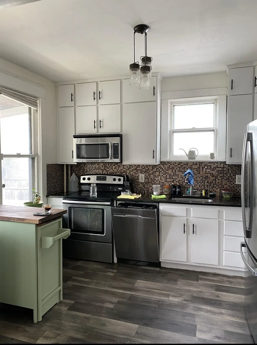 Finished kitchen featuring custom white shaker-style cabinets with black hardware, a mosaic tile backsplash, and integrated appliances as part of Beverwyck Designs' home renovation services.