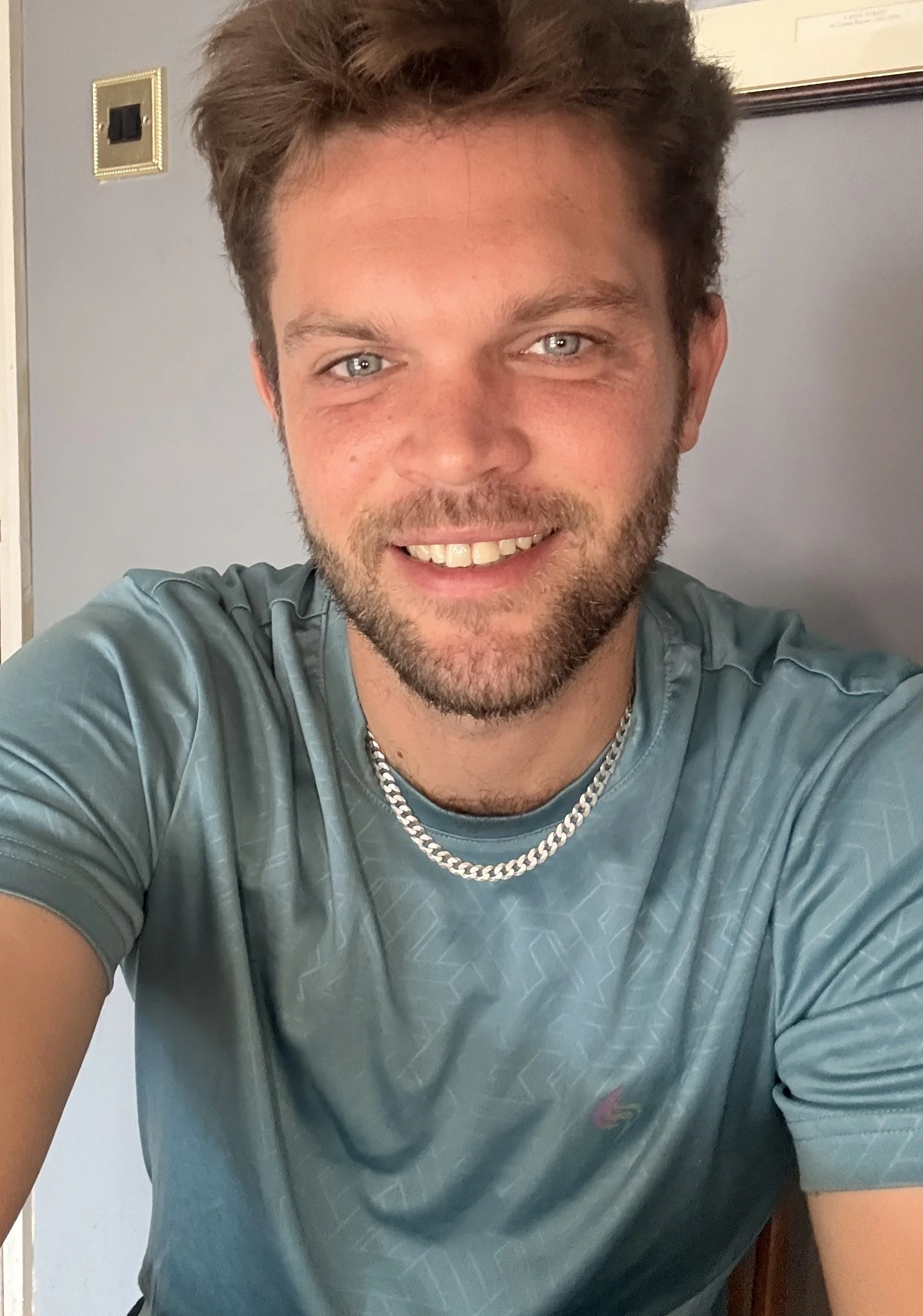 Image shows a man smiling towards the camera