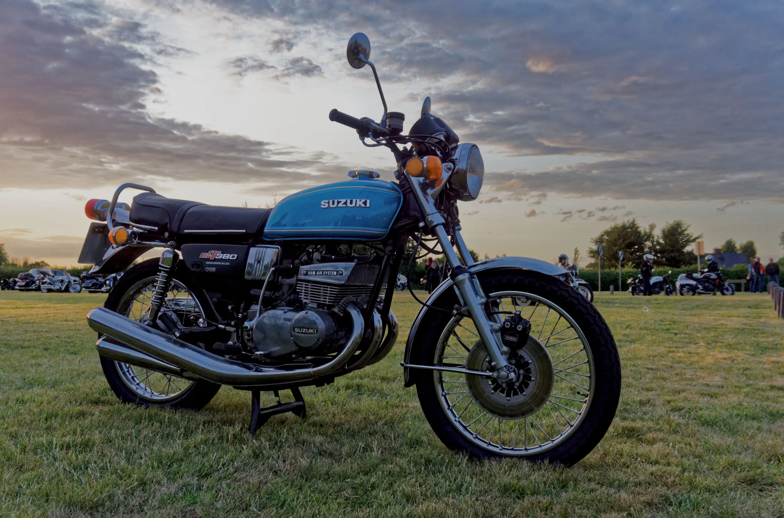 Suzuki GT380 motorcycle at dusk on Ludgershall village green, in Buckinghamshire.