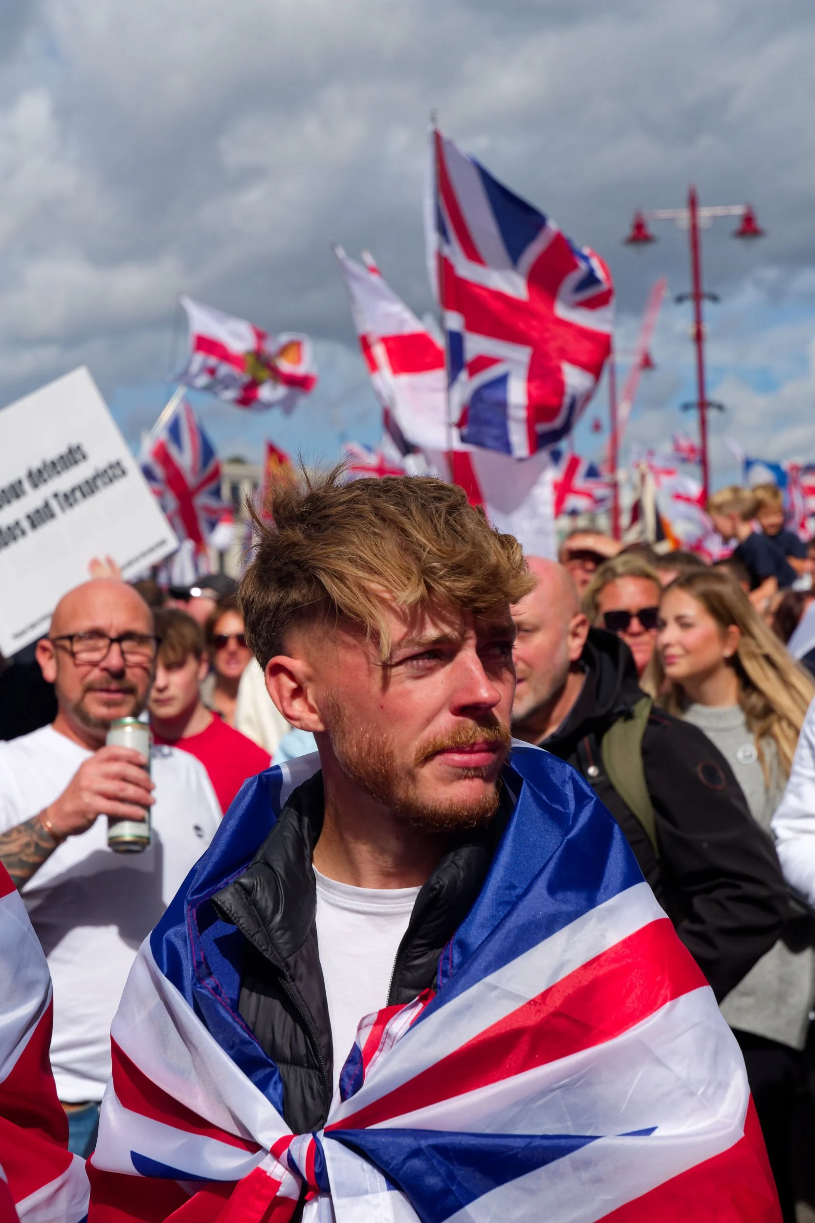 Man wears a Union Jack flag at the Unite the Kingdom march.