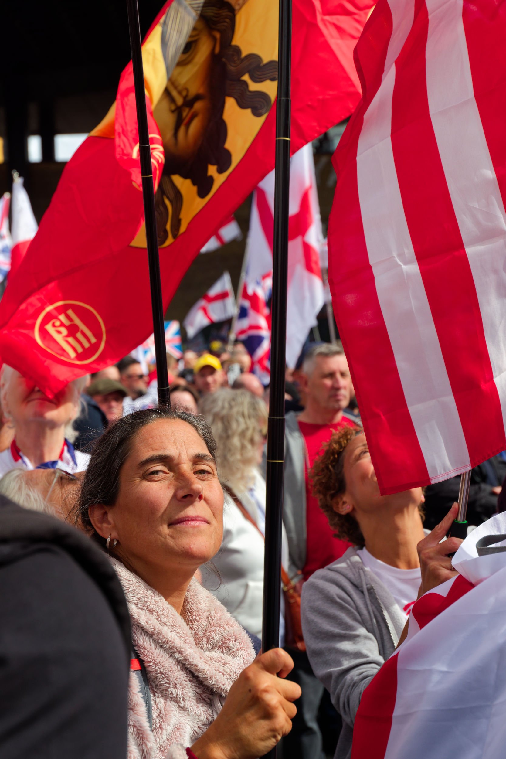 Indian woman holds flag at Unite the Kingdom march.