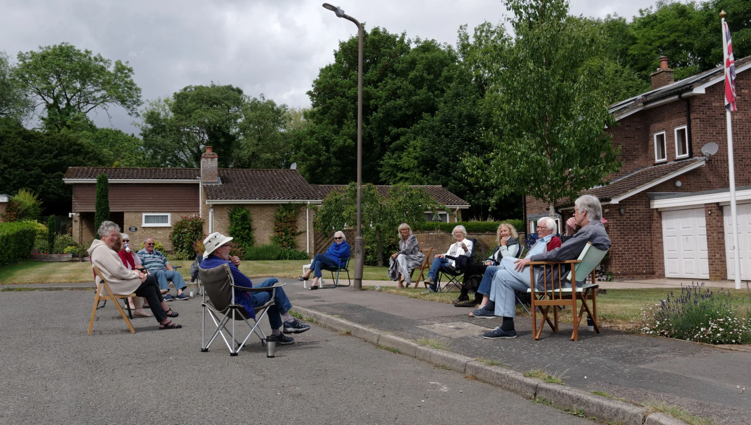 Neighbours have brought their own chairs, to meet for socially distanced coffee.