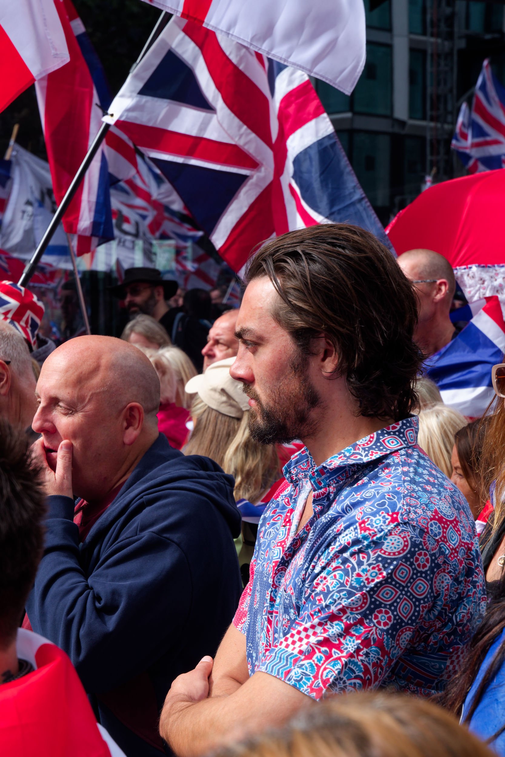 Man wears red, white, and blue shirt at Unite the Kingdom rally.