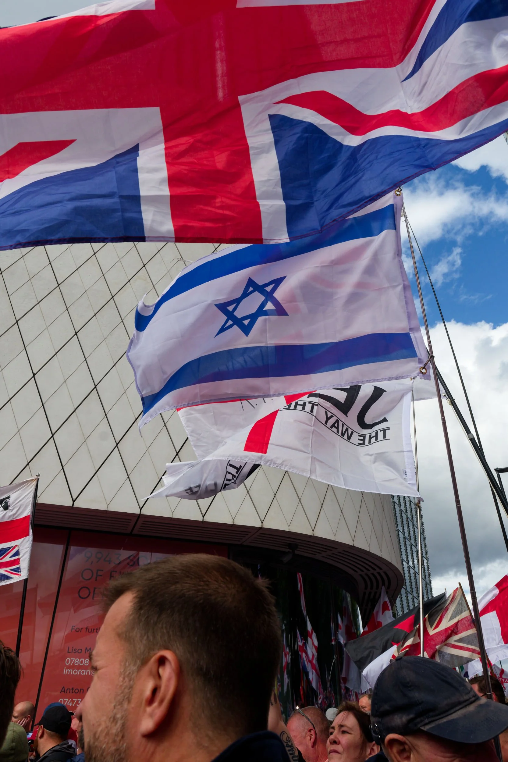 Union Jack, Israeli, and Christian flags at the Unite the Kingdom rally.