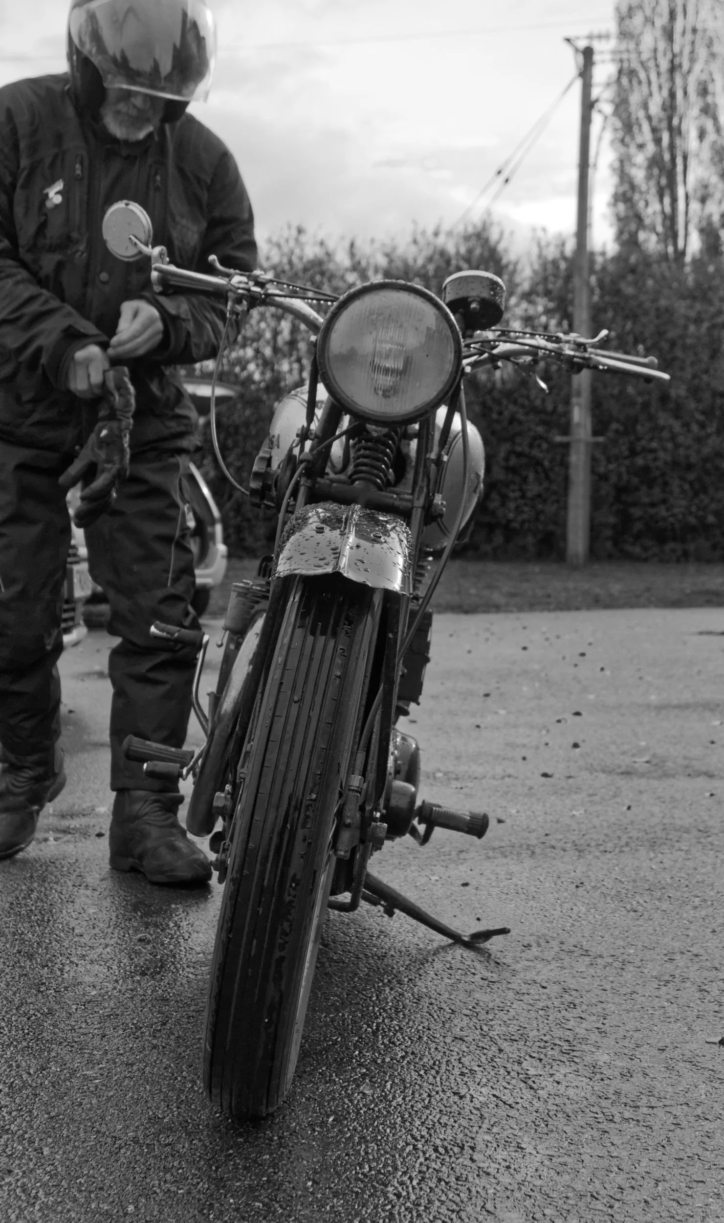 Rider prepares to leave on his BSA M20 classic motorcycle. It's raining.