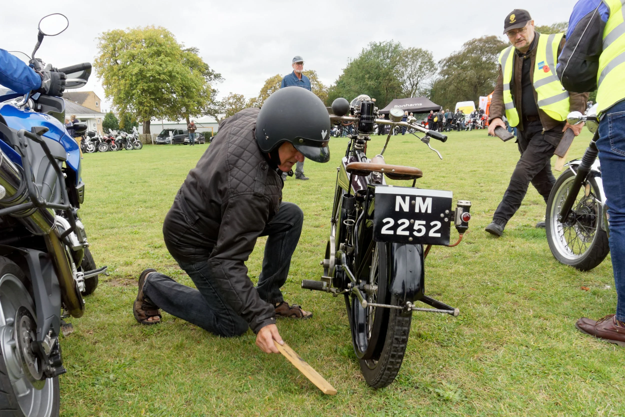 Rider puts his 1921-22 Rex Acme vintage motorcycle on its stand.