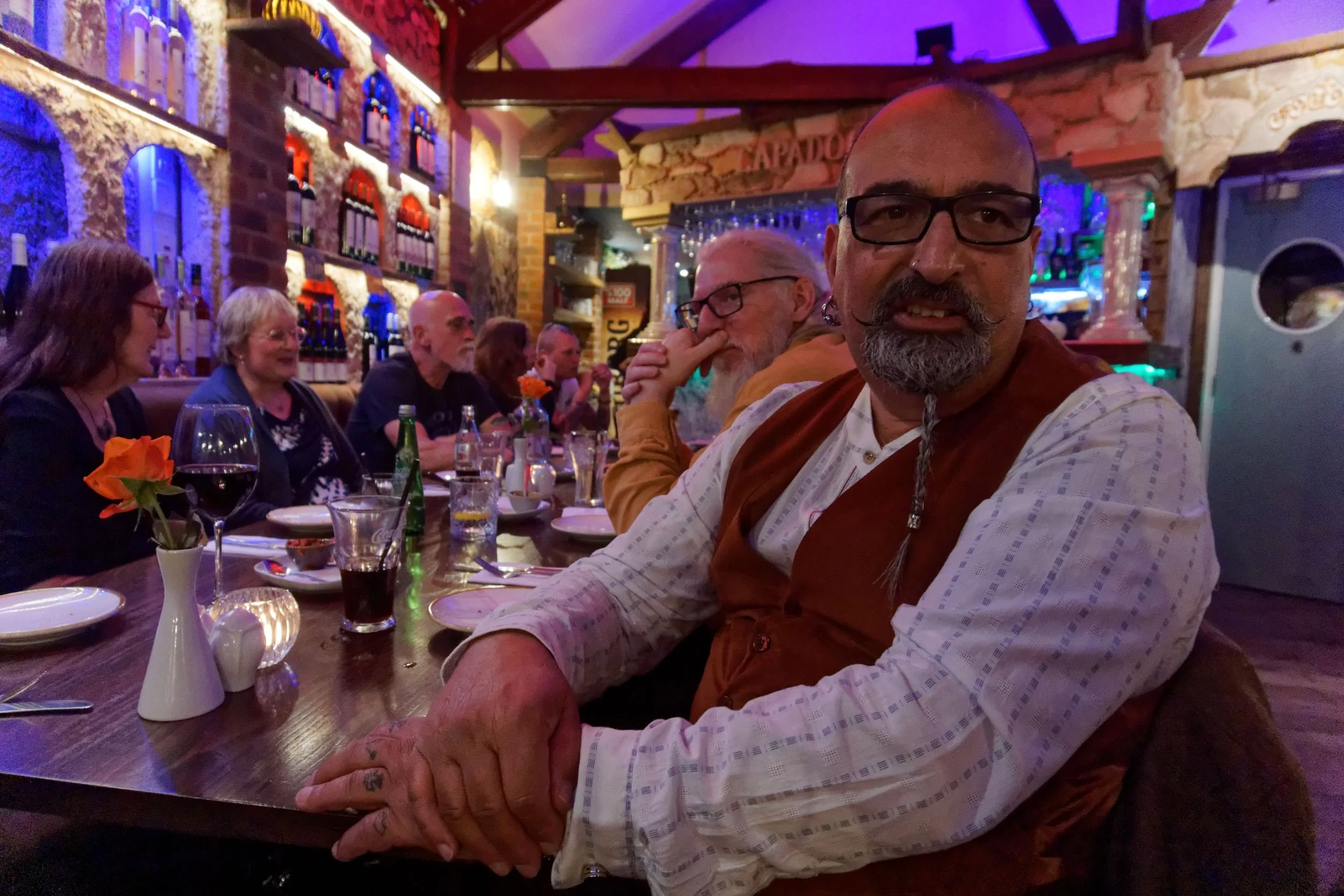 A man wearing a waistcoat at a party in a Turkish restaurant.