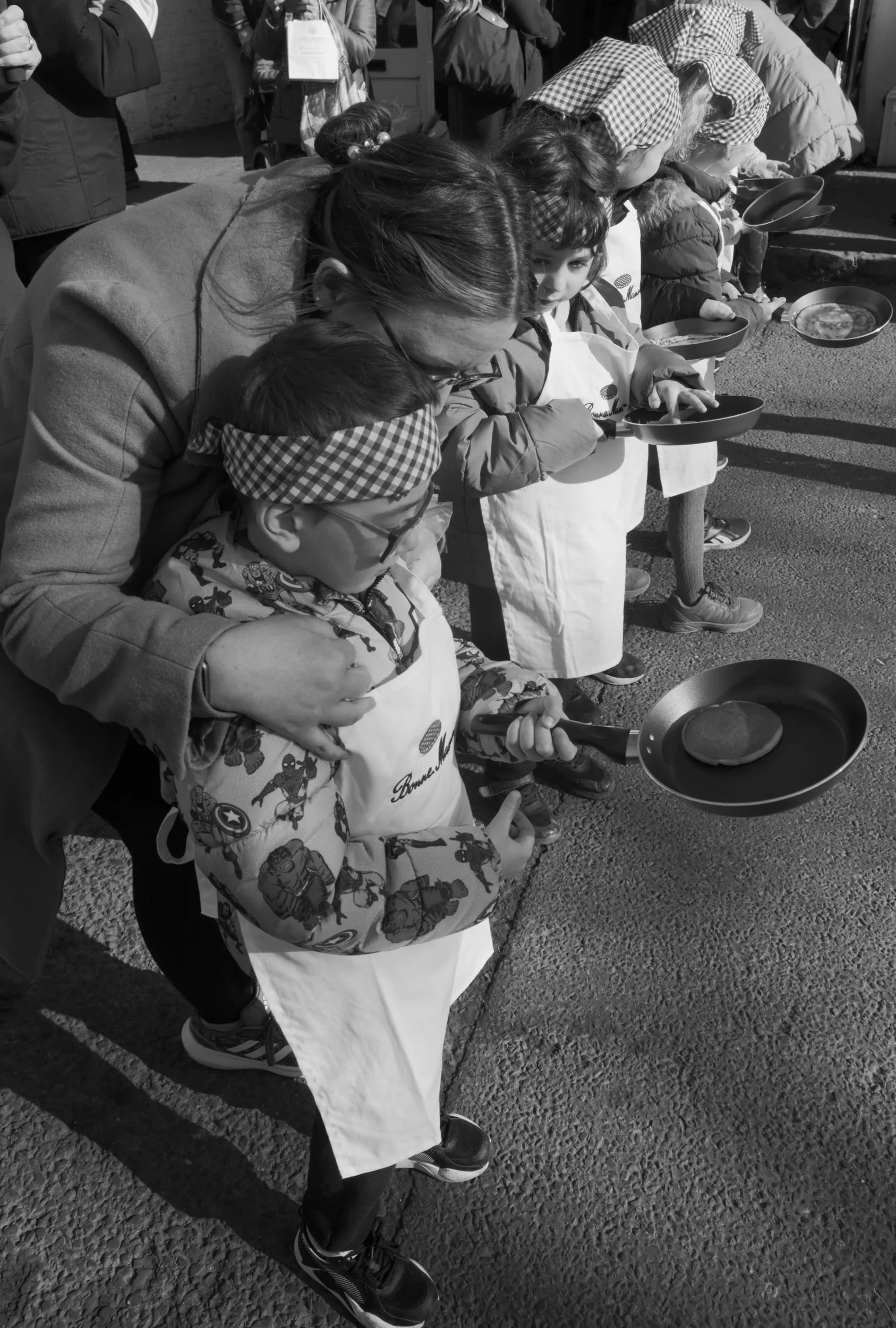 Young boy with frying pan gets ready for his pancake day race.
