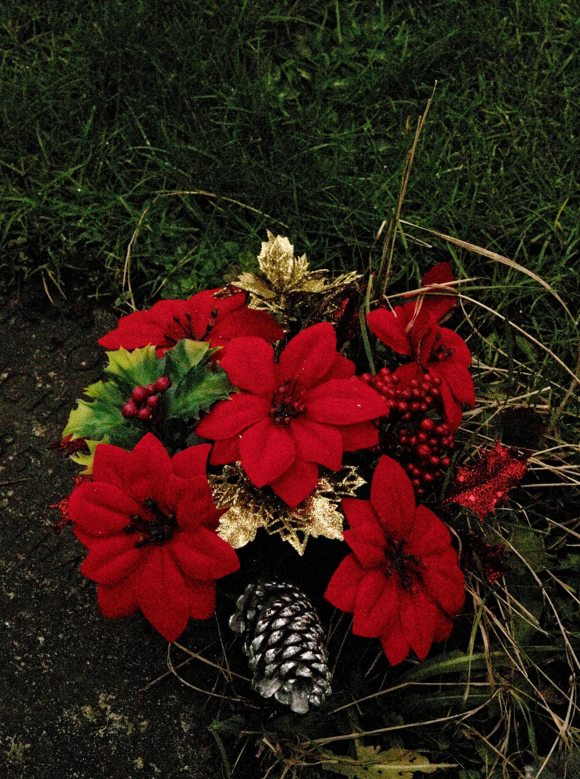 Wreath with red flowers at dusk. A noisy, very high ISO photo.