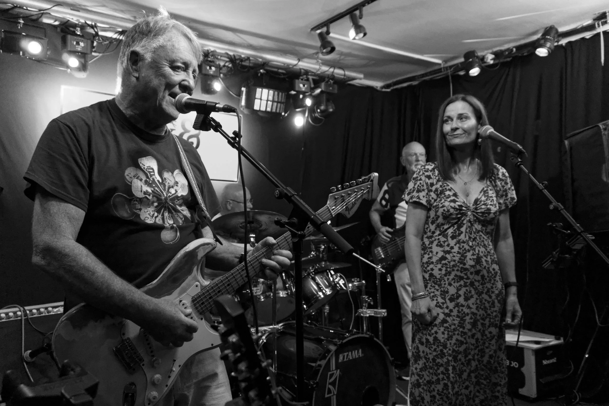 Lead guitarist sings at a pub gig. A black and white photo.