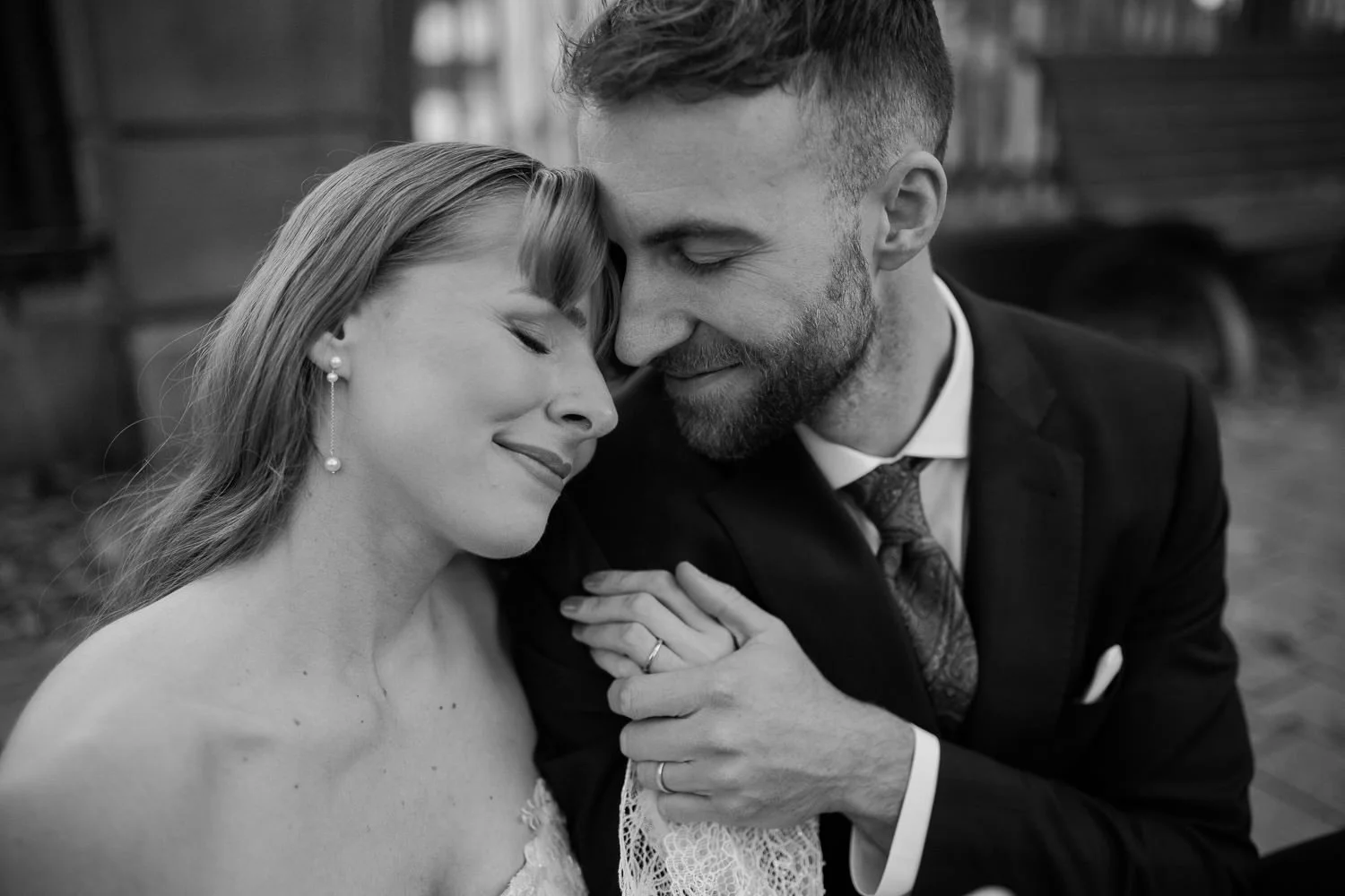 Paarshooting am Hochzeitstag, Brautpaar nimmt sich in den Arm, er hält ihre Hand