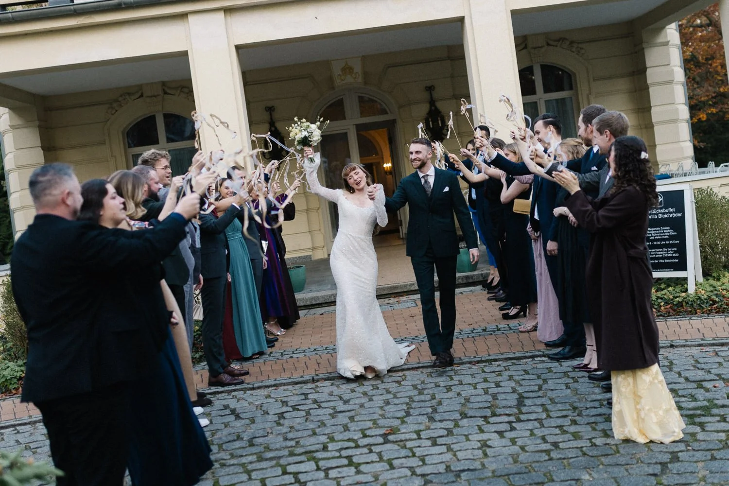 Auszug des Brautpaares aus Villa Bleichröder Usedom, Gäste stehen Spalier mit Luftschlangen