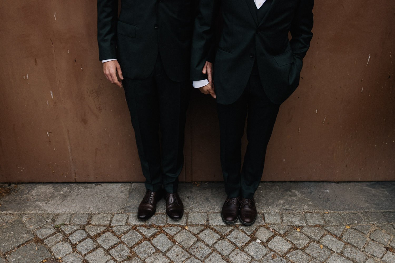 Auschnitt, LGBTQ Hochzeitspaar steht vor brauner Tür