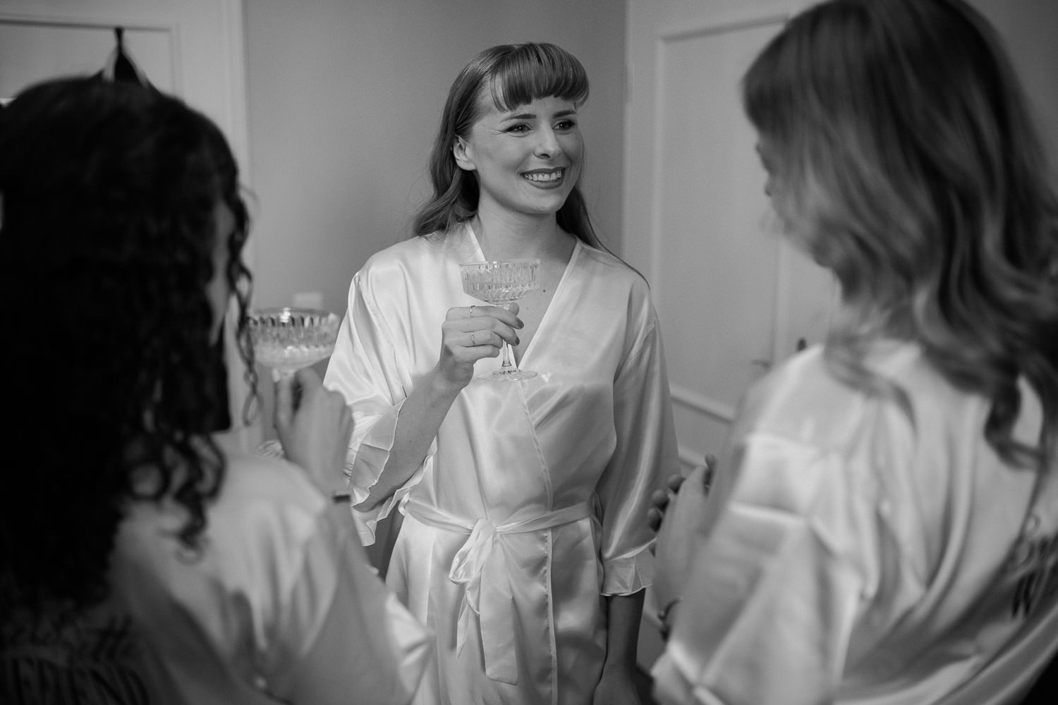 Braut mit Trauzeuginnen beim Getting Ready, Anstoßen mit Sekt, Schwarz-weiß Foto, Hochzeitsfotograf Villa Bleichröder