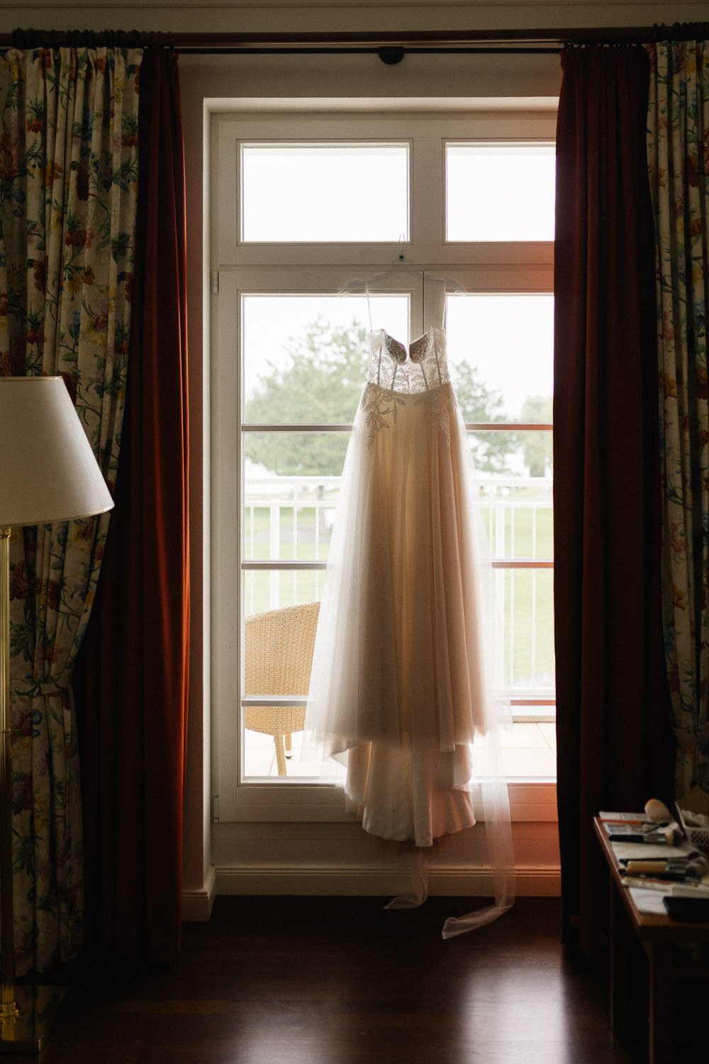 Brautkleid hängt an Fenster in Hotelzimmer, Schwielowsee Resort