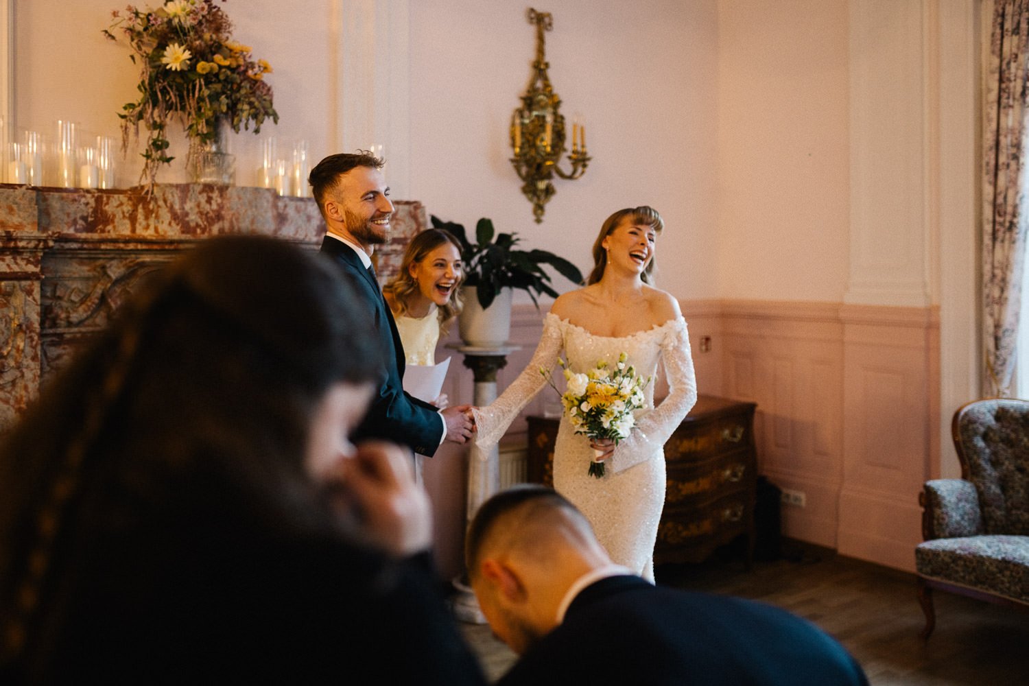 Blick aus Sicht der Hochzeitsgesellschaft auf Brautpaar, Braut lacht, Villa Bleichröder Usedom