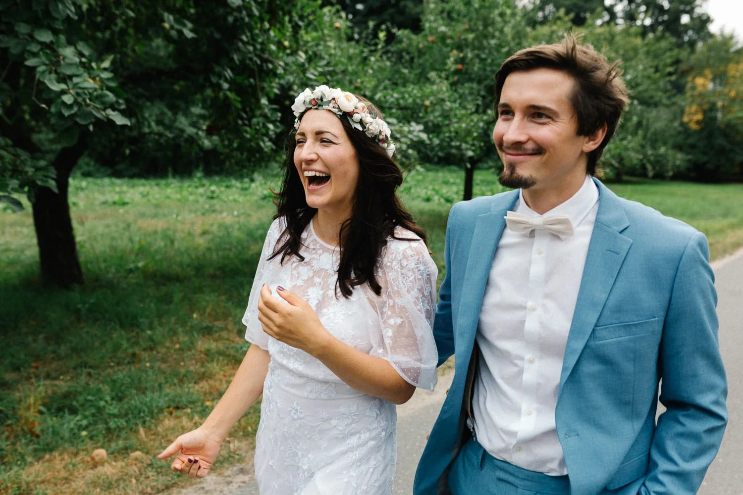 Lachendes fröhliches Brautpaar läuft nebeneinander