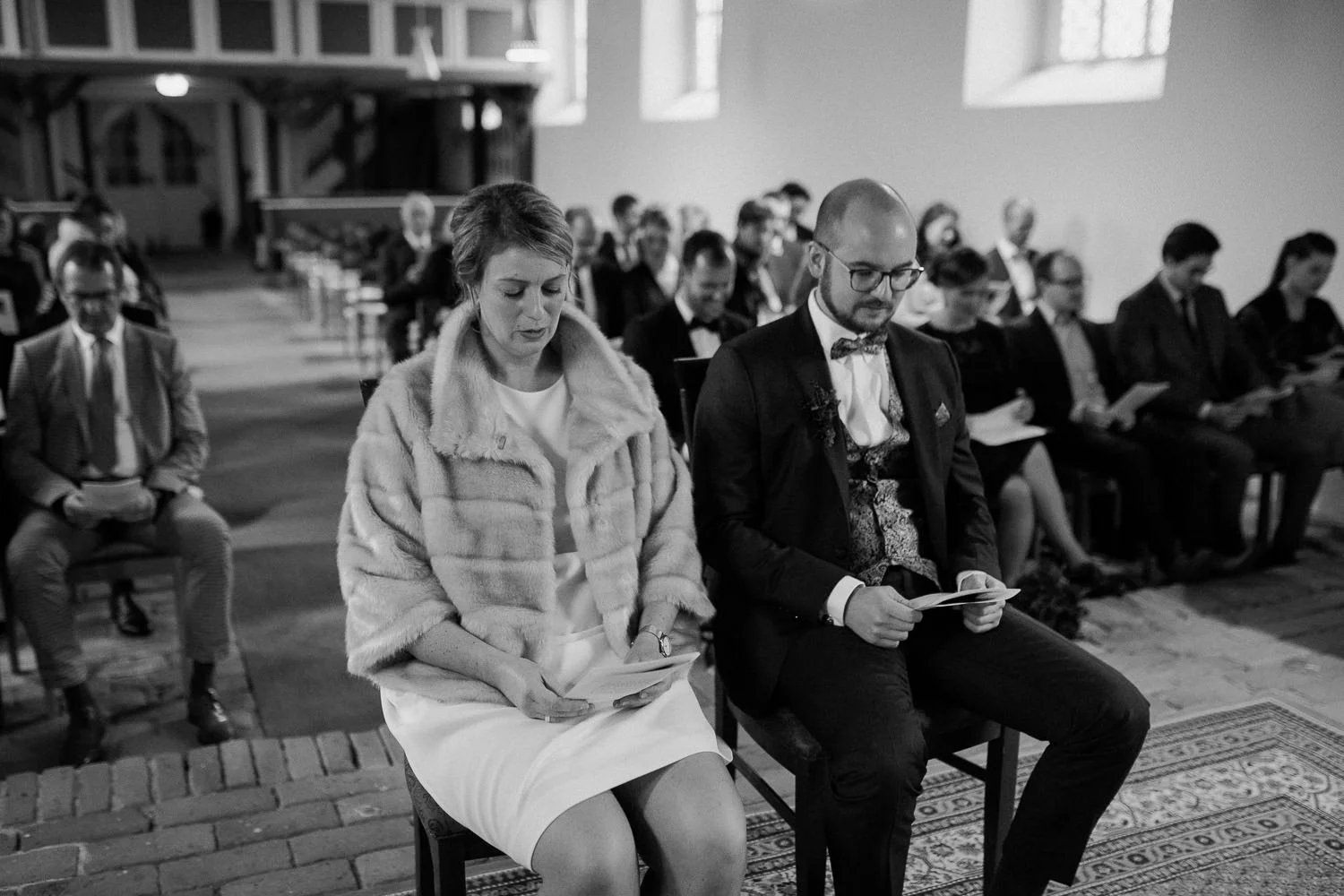 Brautpaar während Trauung, sitzend, Schwarz-weiß Foto