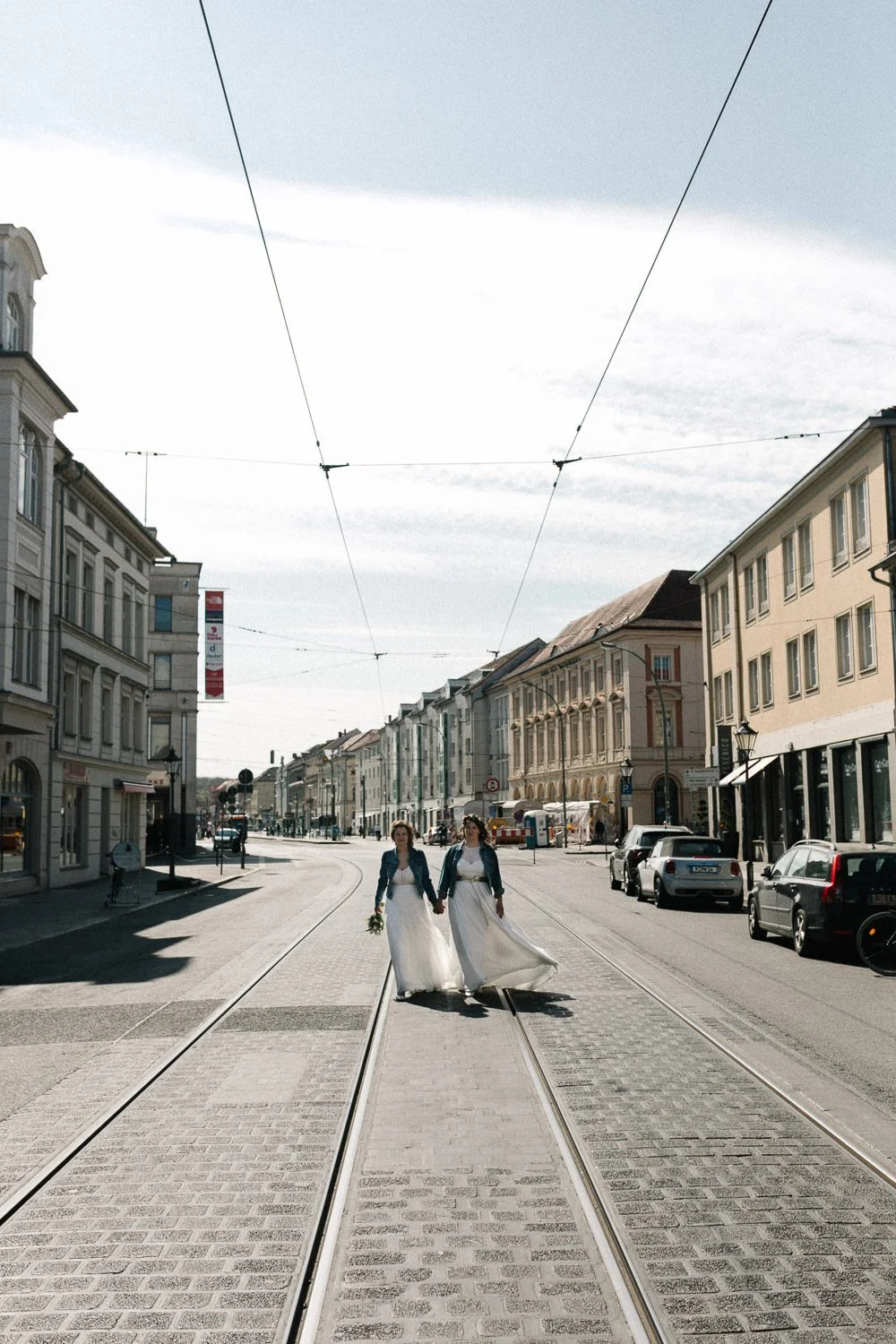 LGBTQ Hochzeitsfotos Potsdam zwei Frauen laufen Hand in Hand auf Straße
