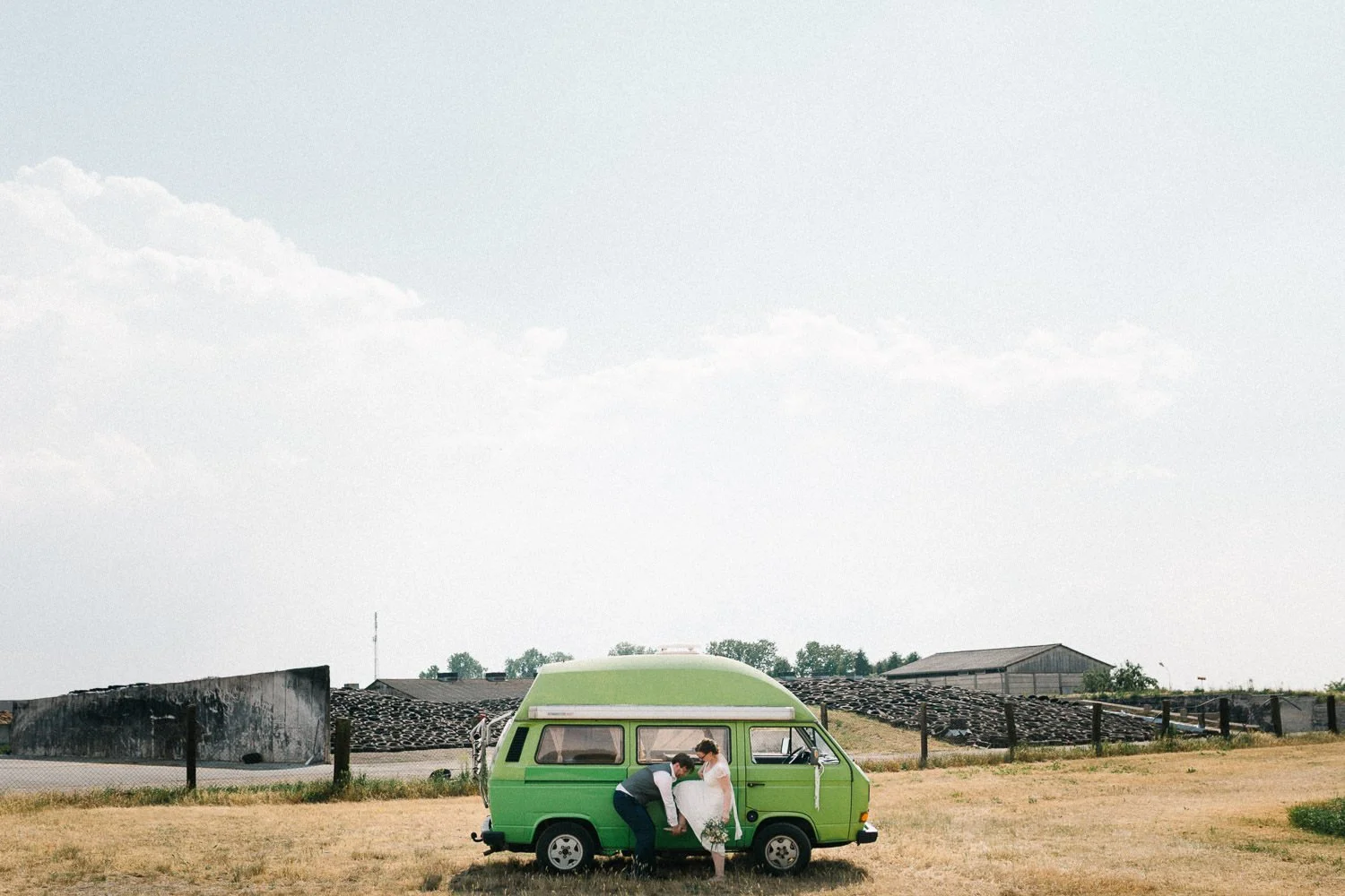 Brautpaar steht vor grünem VW T3 Bulli