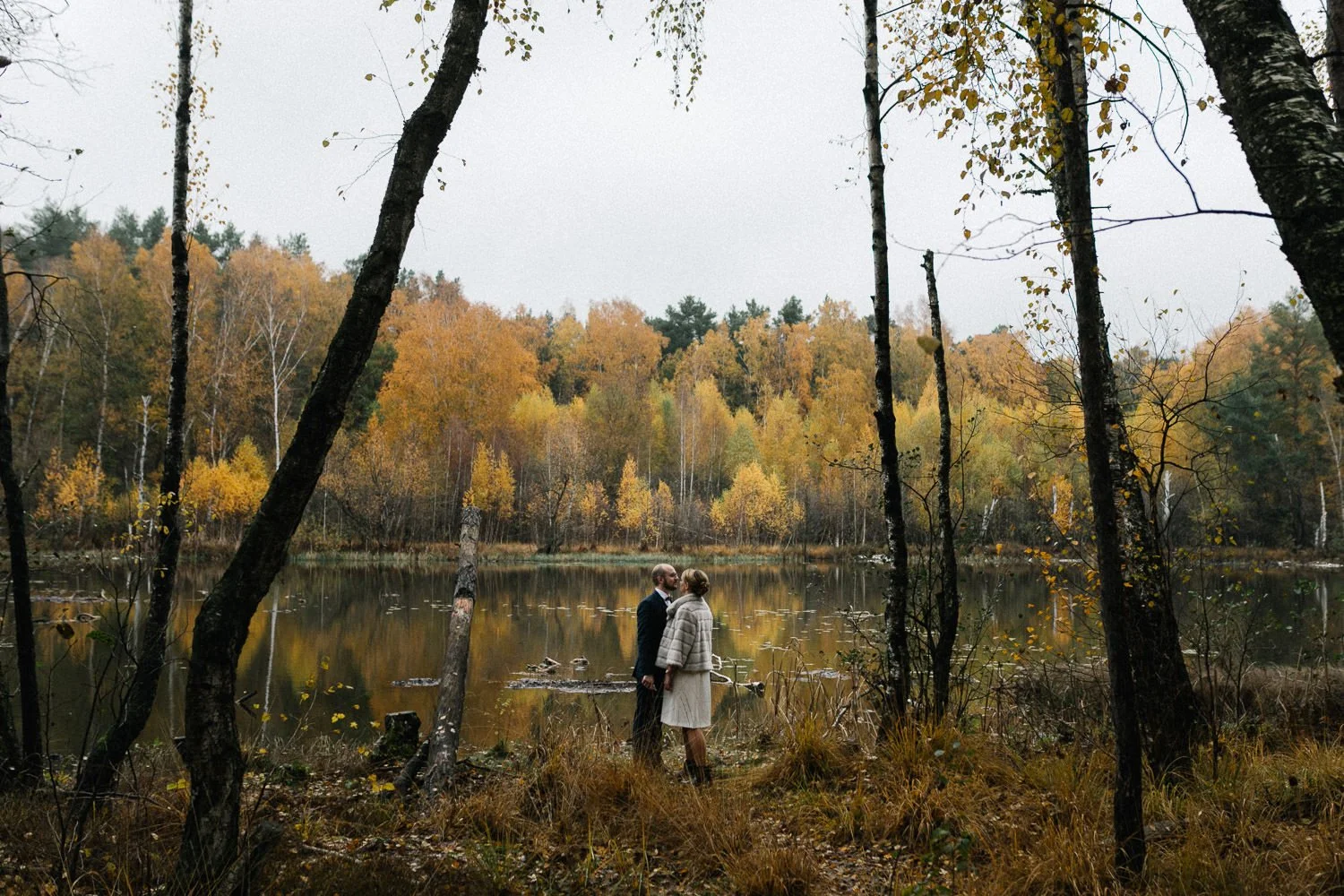 Brautpaar von hinten an See im Herbst